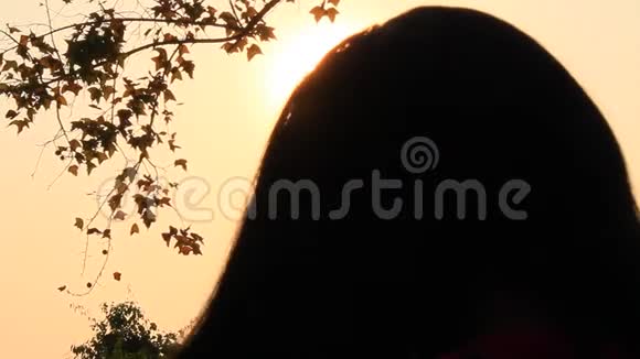 女孩在日落时抚摸头发视频的预览图