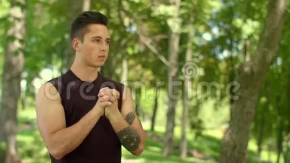 运动员在夏季公园伸展手腕有魅力的男人热身肌肉视频的预览图