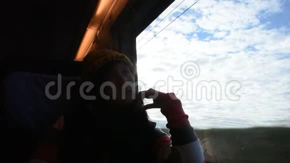 亚洲泰国妇女坐在火车上从火车上观看乡村景观和城市景观视频的预览图