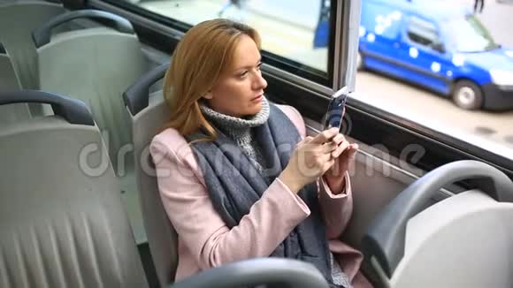 年轻漂亮的女士乘旅游观光车旅行带着智能手机视频的预览图