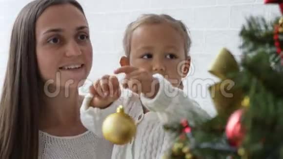 快乐的女孩母女在家装饰圣诞树视频的预览图
