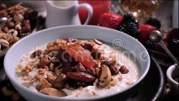 慢镜头浆果落在一碗酸奶上早餐是浆果和干水果视频的预览图