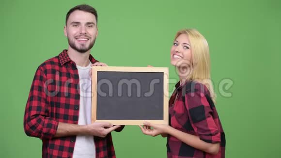 年轻的幸福夫妇一起拿着黑板视频的预览图