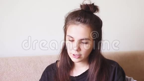 生病的年轻妇女坐在家里流鼻涕打喷嚏视频的预览图