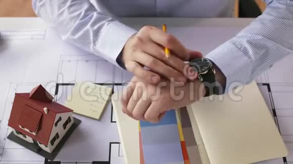 建筑师在手表上检查时间并离开视频的预览图