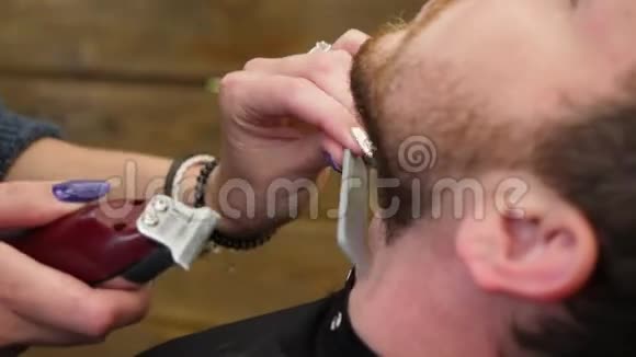 专业理发师用剃须刀机刮胡子侧景肖像英俊的年轻留胡子的男人视频的预览图
