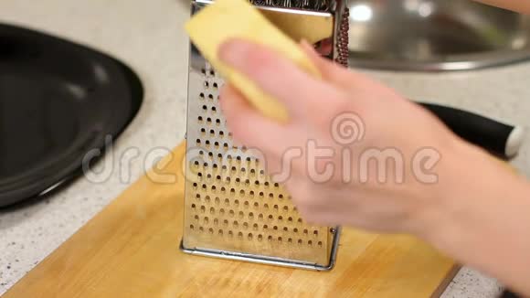 在厨房桌子上的烤架上擦奶酪压碎奶酪女人的奶酪披萨的准备视频的预览图
