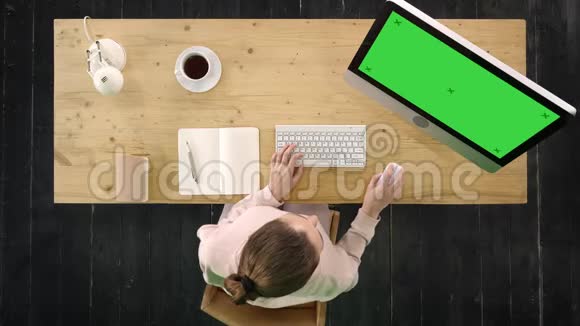 年轻的女人在电脑上工作坐在办公桌前绿色屏幕模拟显示视频的预览图