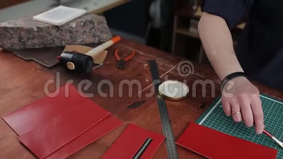 皮匠正在用特殊的刷子在拉链的皮革部件上涂上胶水他在桌子旁工作视频的预览图