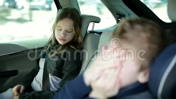 一家人开车去度假孩子们在车后座睡觉视频的预览图