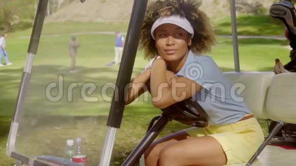 坐在高尔夫球车上的漂亮年轻女子视频的预览图