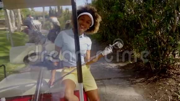 在高尔夫球车里微笑友好的女高尔夫球手视频的预览图