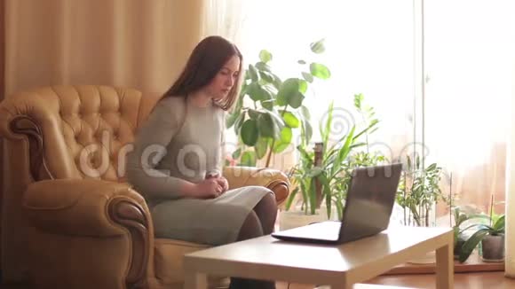 漂亮的年轻女人在房间里用笔记本电脑社交视频的预览图