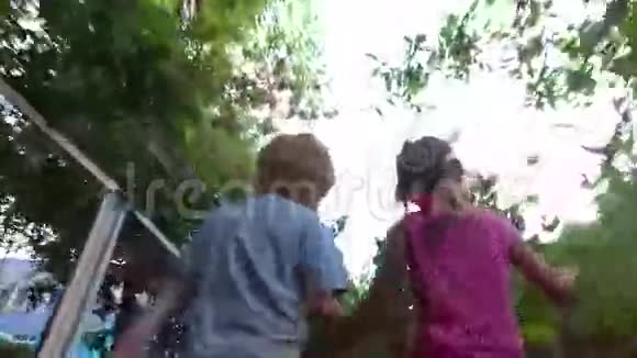 有耳朵和辫子的女孩和白发的男孩沿着篱笆走着视频的预览图