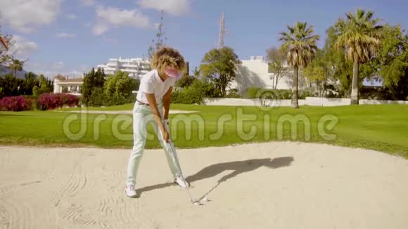 年轻女子高尔夫球手在地堡里玩视频的预览图