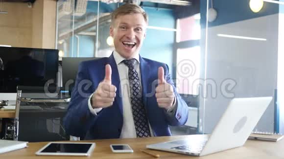 快乐的商人在办公室里竖起大拇指对着镜头视频的预览图