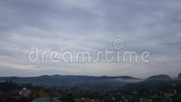 多雨的灰色春云笼罩着山中的小镇时光飞逝视频的预览图