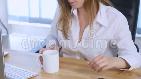 手机上的智能手机女孩在办公室里微笑着喝咖啡美丽的多元文化年轻休闲女性视频的预览图