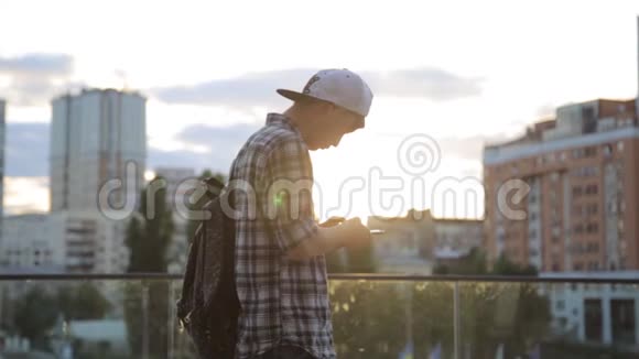 英俊的亚洲学生男子打字智能手机城市市中心夜灯通信技术4g接收短信视频的预览图