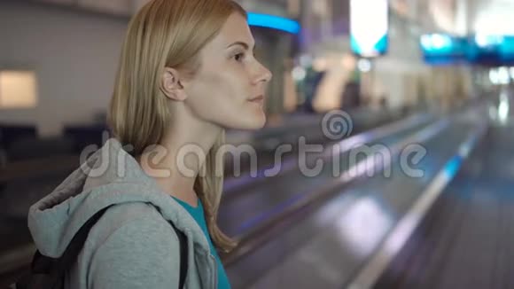 机场航站楼里漂亮迷人的女人在等飞机使用牵引器环顾四周视频的预览图
