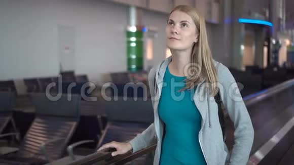 机场航站楼里漂亮迷人的女人在等飞机使用牵引器环顾四周视频的预览图
