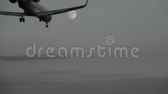 黄昏时分在满月的衬托下喷气式飞机缓慢降落视频的预览图