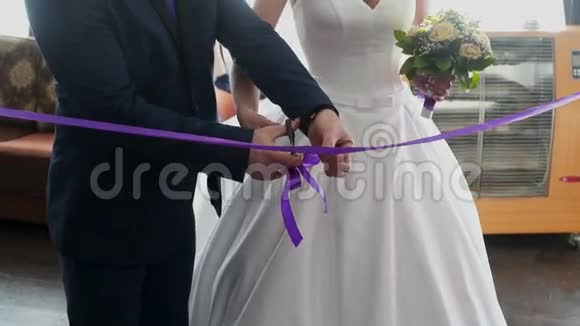 新娘和新郎剪紫色带视频的预览图
