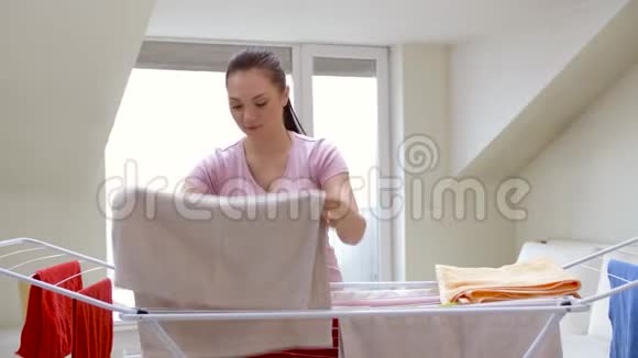 从家里的晾衣架上拿浴巾的女人视频的预览图