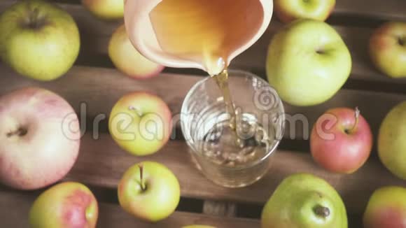 从一个陶罐里慢慢地把果汁倒入玻璃杯里视频的预览图