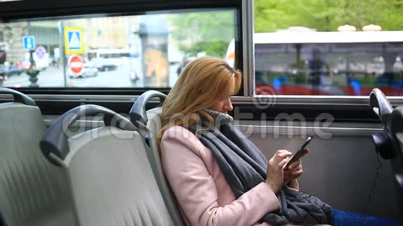 年轻漂亮的女士乘旅游观光车旅行带着智能手机视频的预览图