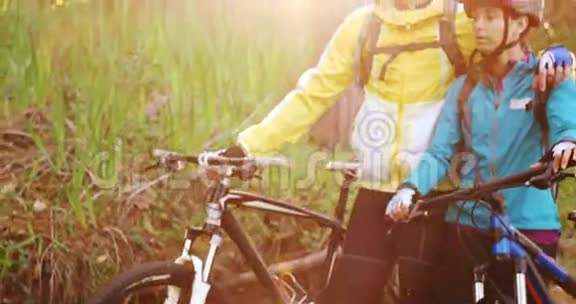 山地自行车夫妇骑着自行车在森林小径上行走视频的预览图
