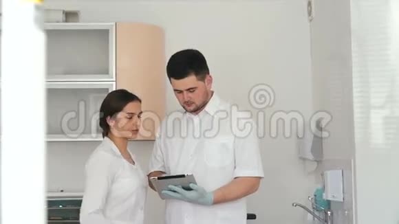 牙医与漂亮的女性助理讨论他的病人的诊断视频的预览图