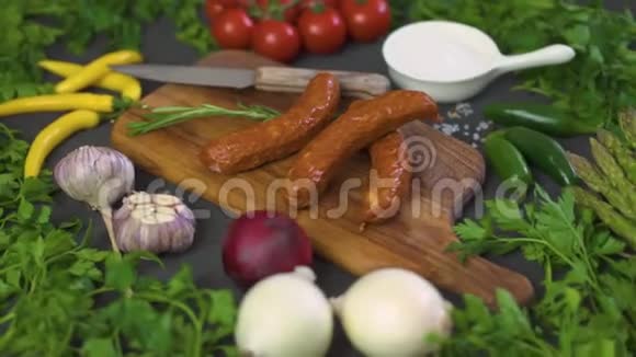 美味的香肠木板上有不同蔬菜黑桌上有刀视频的预览图
