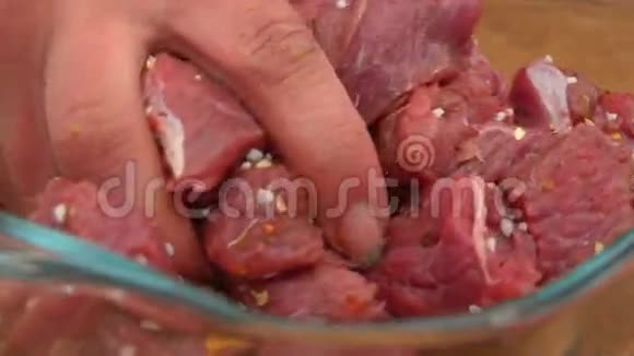 特写一只手搅拌着新鲜肉片视频的预览图