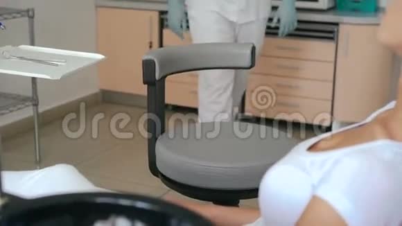 在牙科室和牙医谈话的漂亮女孩视频的预览图