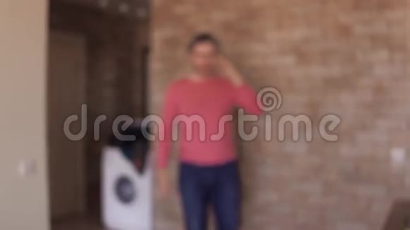 穿着粉红色T恤的开朗男人在家里用手机说话4K近距离射击视频的预览图