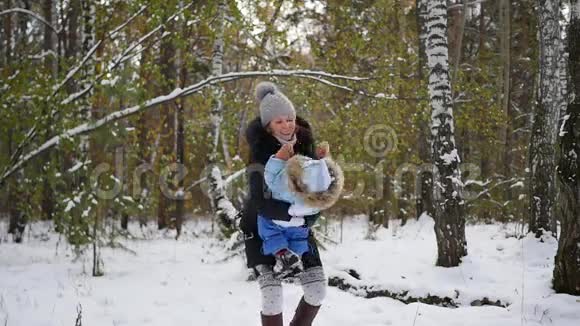 妈妈在冬天公园和宝宝玩纺纱视频的预览图