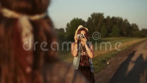 少女潮人在电影摄影机上给女友拍照两名年轻妇女在黎明时被拍照慢动作视频的预览图