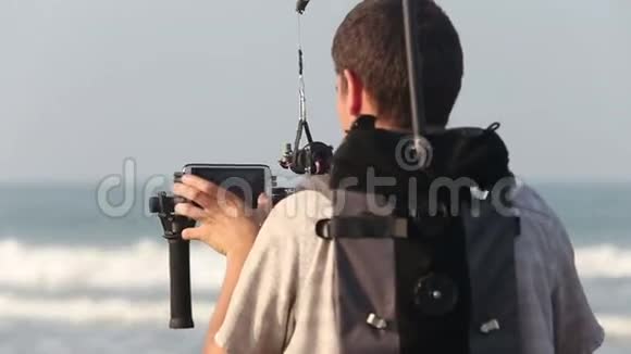 视频操作员在海滨用稳定系统拍摄人员视频的预览图