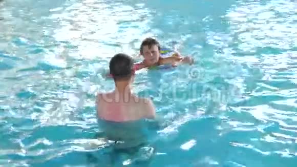 两个男孩在游泳池里玩耍视频的预览图