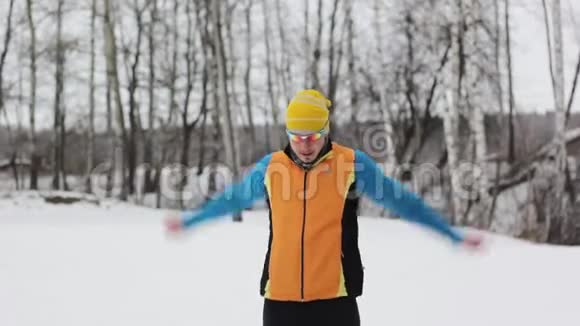 在白雪覆盖的森林里做运动的运动员视频的预览图