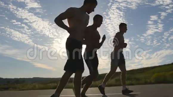 日落时分强壮的男人在乡间小路上慢跑的剪影马拉松跑男子慢跑训练组视频的预览图