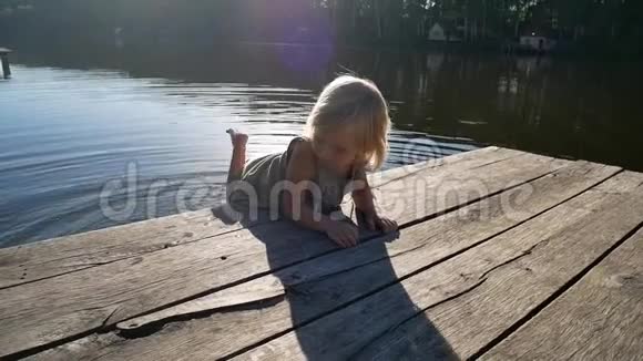 孩子从桥上尝试池塘里的水视频的预览图