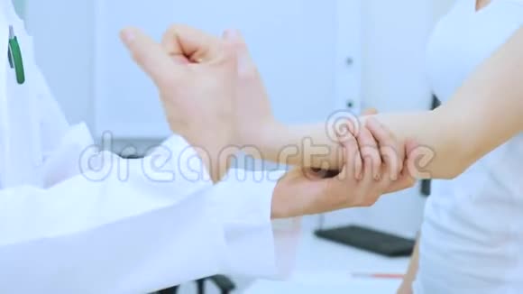 医生在受伤后帮助女孩弯曲手腕视频的预览图