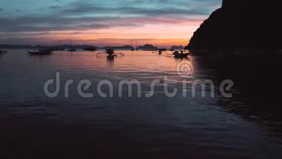 日落时在热带海湾的船只和游艇的鸟瞰图ElNido巴拉望菲律宾海洋热带日落视频的预览图