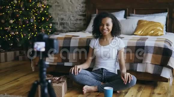 一位年轻的混血女孩在博客上录制关于在家包装圣诞礼物盒的视频视频的预览图