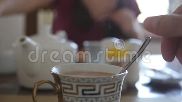 男性手在一杯热咖啡或茶中搅拌糖或牛奶慢动作关闭视频的预览图