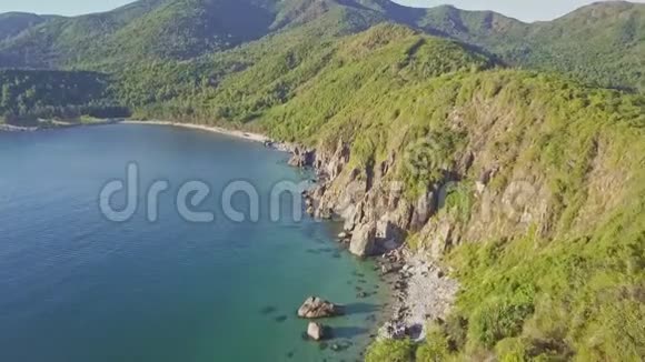 鸟瞰蓝色海洋和绿色丘陵落基海岸视频的预览图