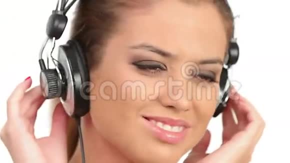 漂亮的女士戴着大耳机听音乐看着相机亲吻对方视频的预览图