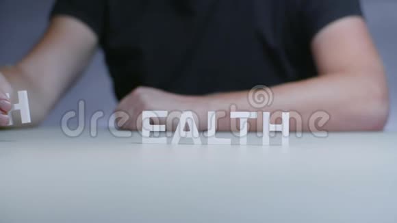 男人的双手组成健康字从白色塑料字母灰色背景视频的预览图